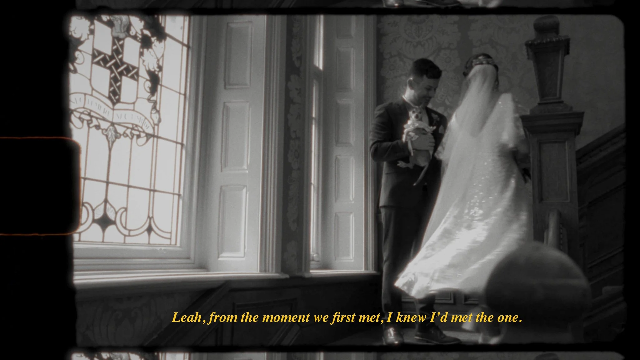 A bride and groom standing on a staircase, with stained glass window in the background, during a wedding ceremony. The groom is holding a bouquet, and the bride is wearing a veil and gown. The scene has a vintage, black and white aesthetic with yello