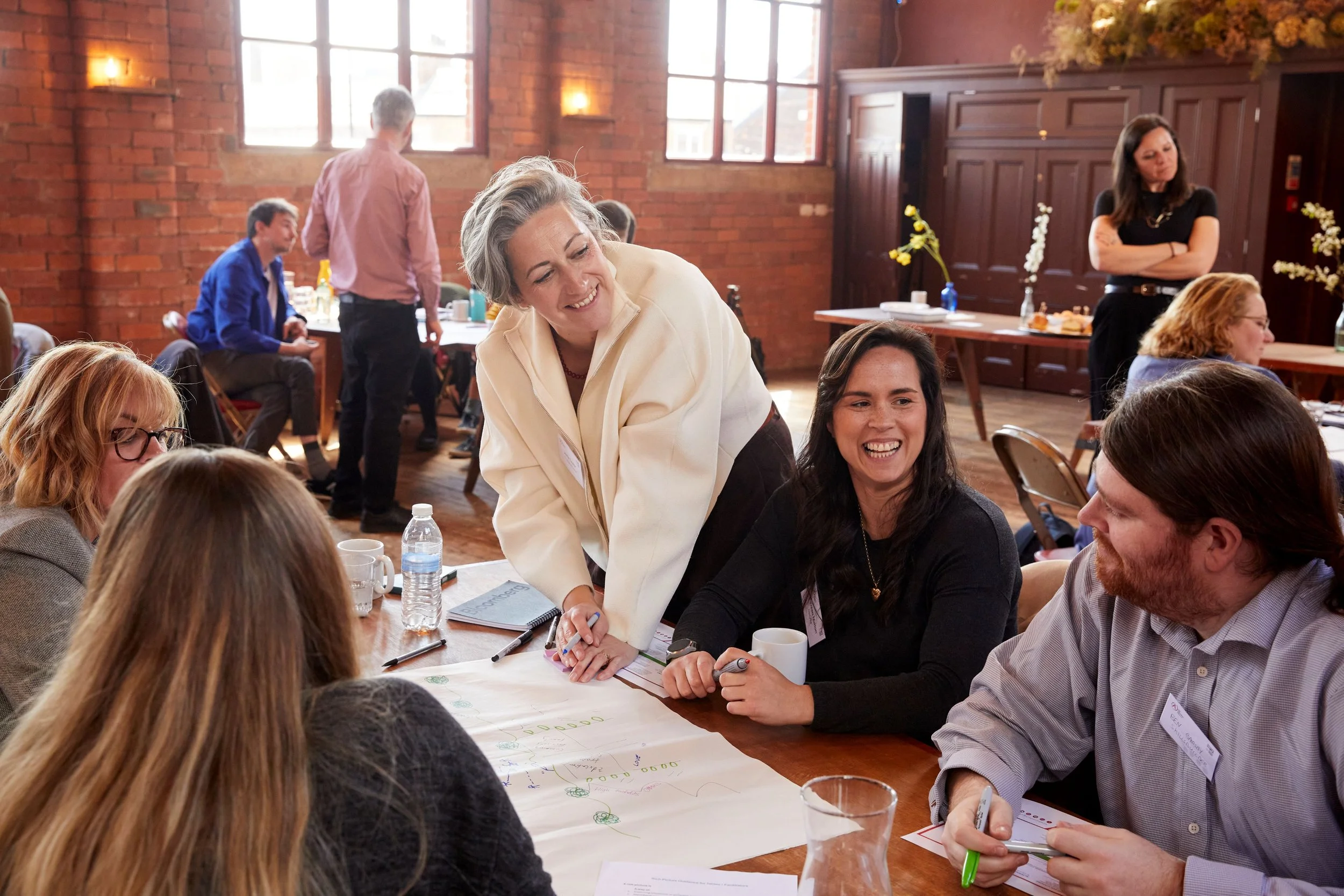 Group of people sitting round a table writing on a large piece of paper