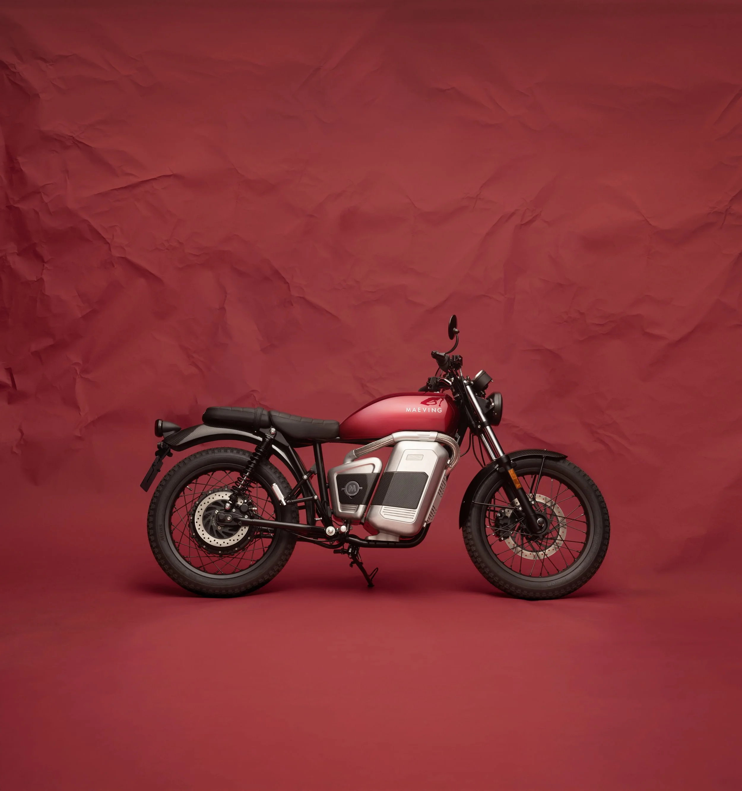 Moto électrique sur fond de mur en papier rouge