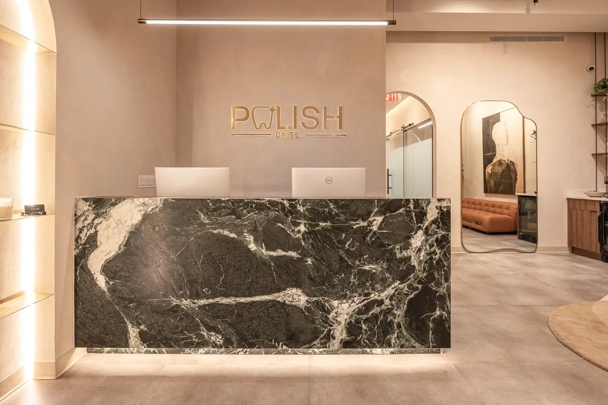 Modern reception area at Polish Dental in NoHo, New York City featuring warm wood finishes, custom millwork, soft lighting, and hospitality-inspired design.