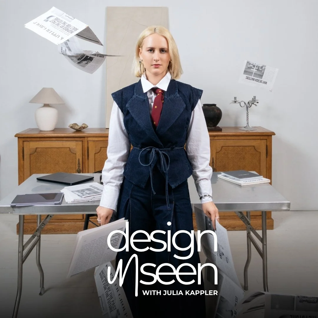 A woman with blonde hair and a serious expression standing in a room with a cane and a wooden cabinet, surrounded by flying newspapers and papers on a table, with the words 'design unseen with Julia Kappler' overlayed.