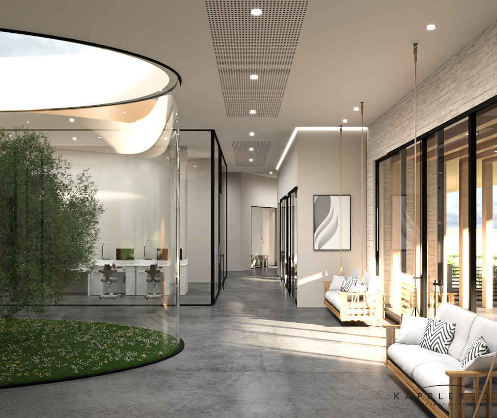 Modern interior lounge area with white sofas, pillows, large windows, and a small indoor garden with a glass wall structure.