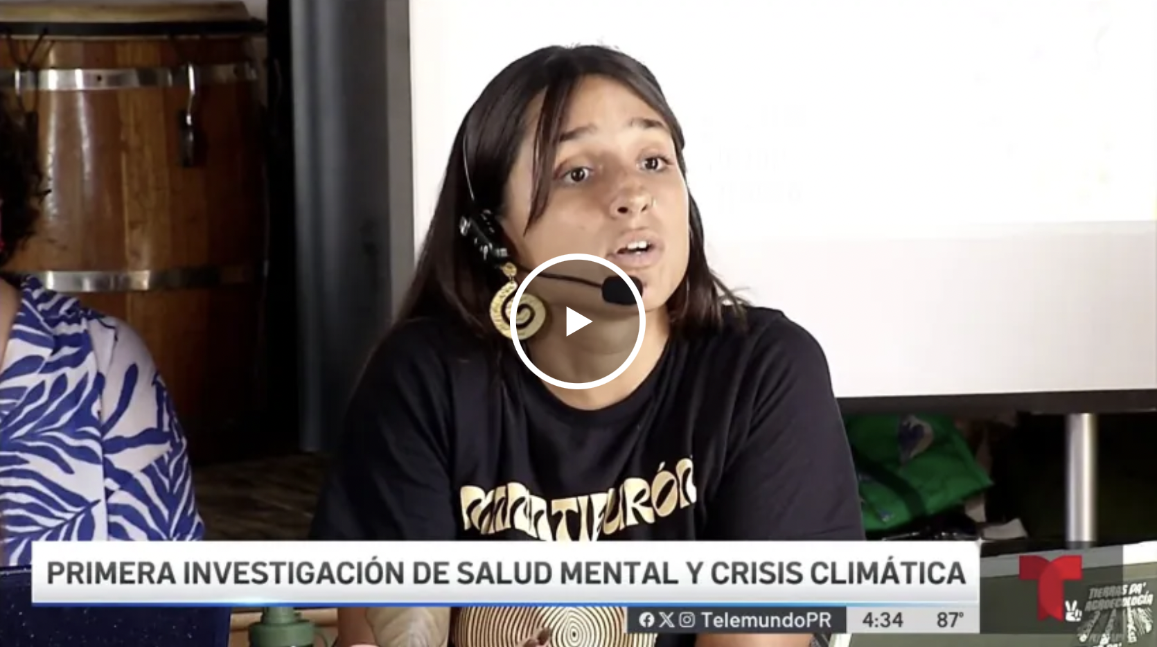 Mujer con auriculares y micrófono, participando en una discusión o entrevista sobre salud mental y crisis climática, con un banner que dice "Primera investigación de salud mental y crisis climática".
