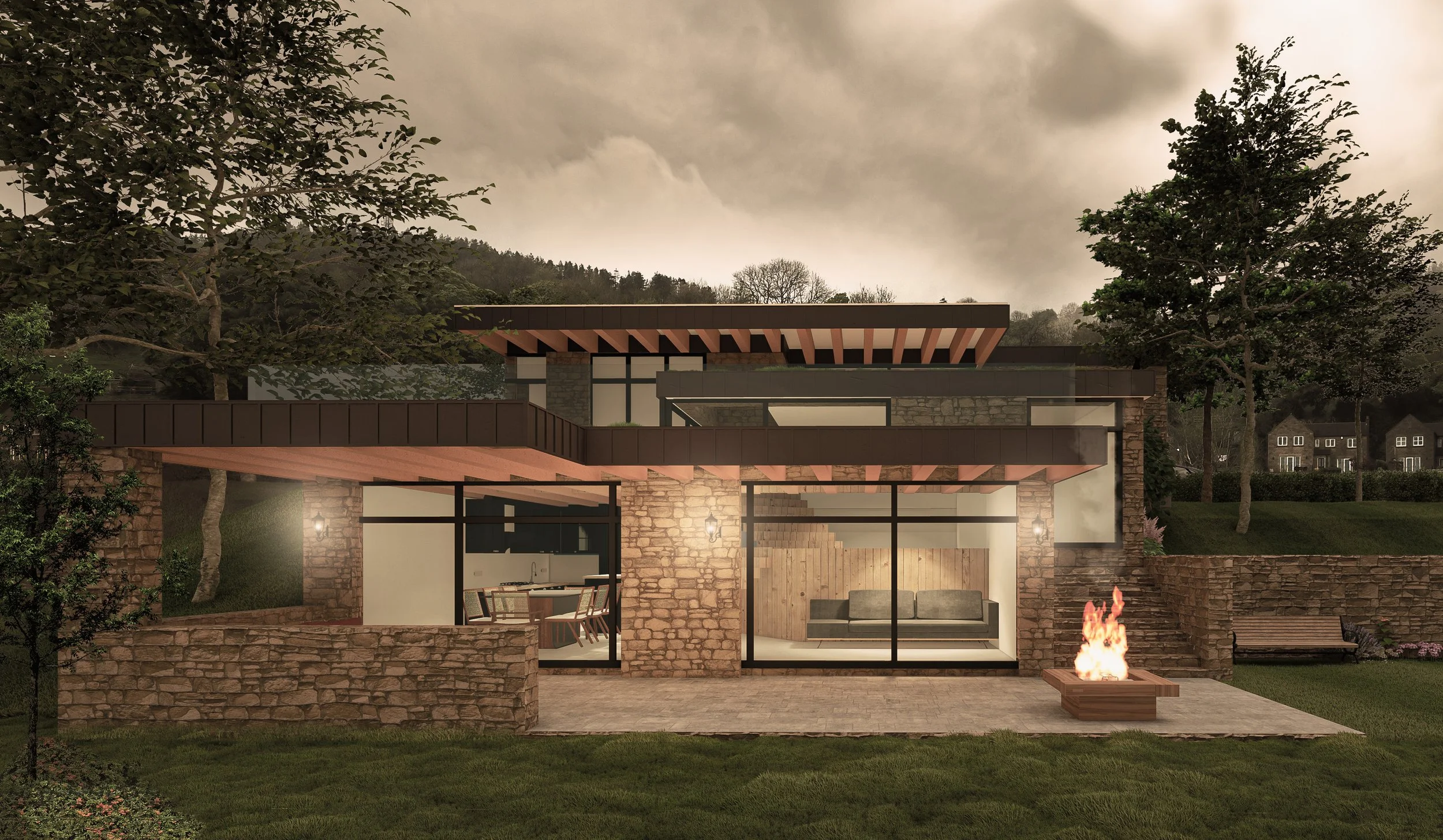 Guy Taylor Associates — Modern house with stone walls, large glass windows, a fire pit outside, and a lush green yard, set against a backdrop of trees and a cloudy sky.