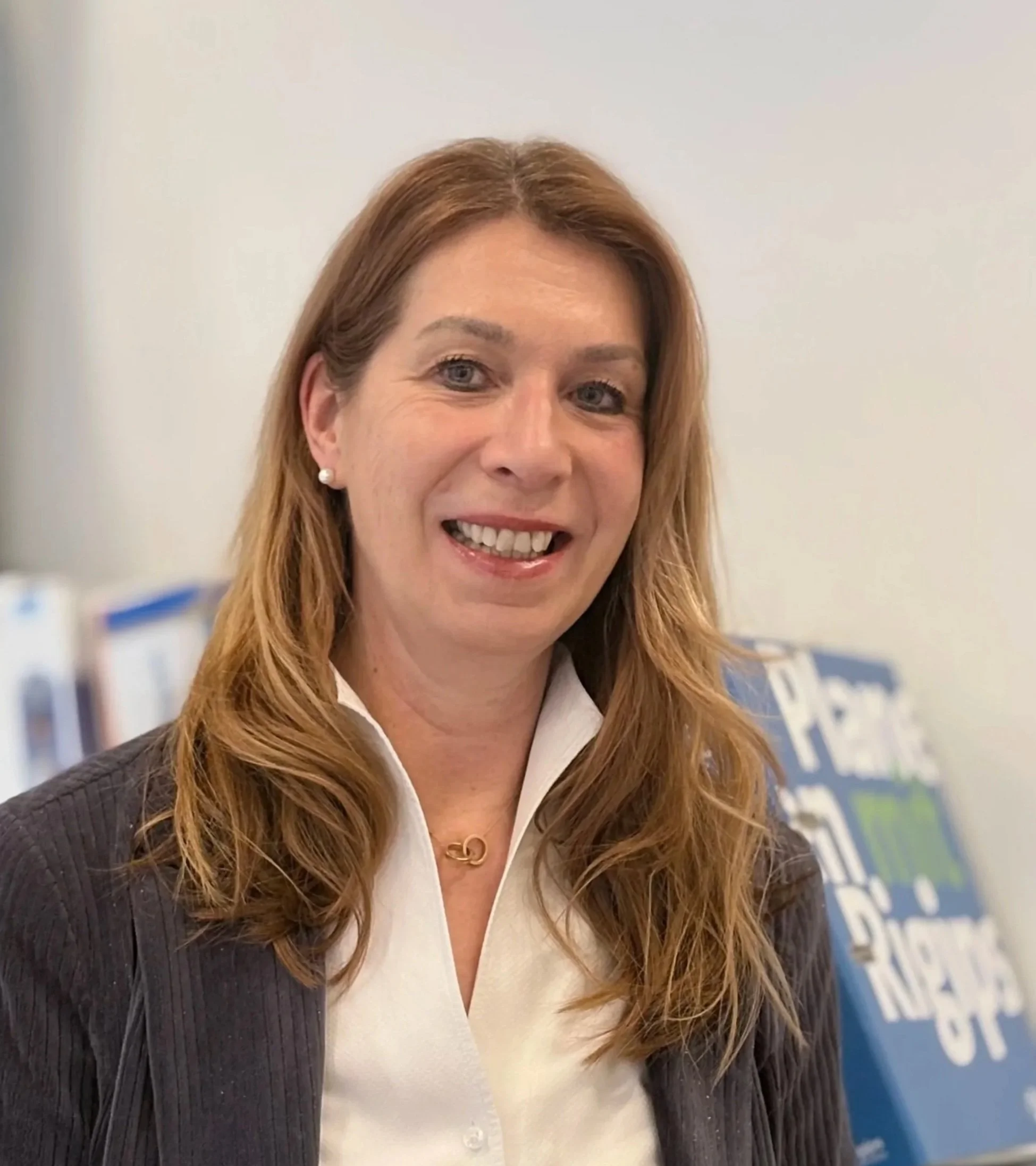 Nahaufnahme von Palmen mit langen, grünen Blättern gegen einen beigefarbigen Himmel im Sonnenuntergang.