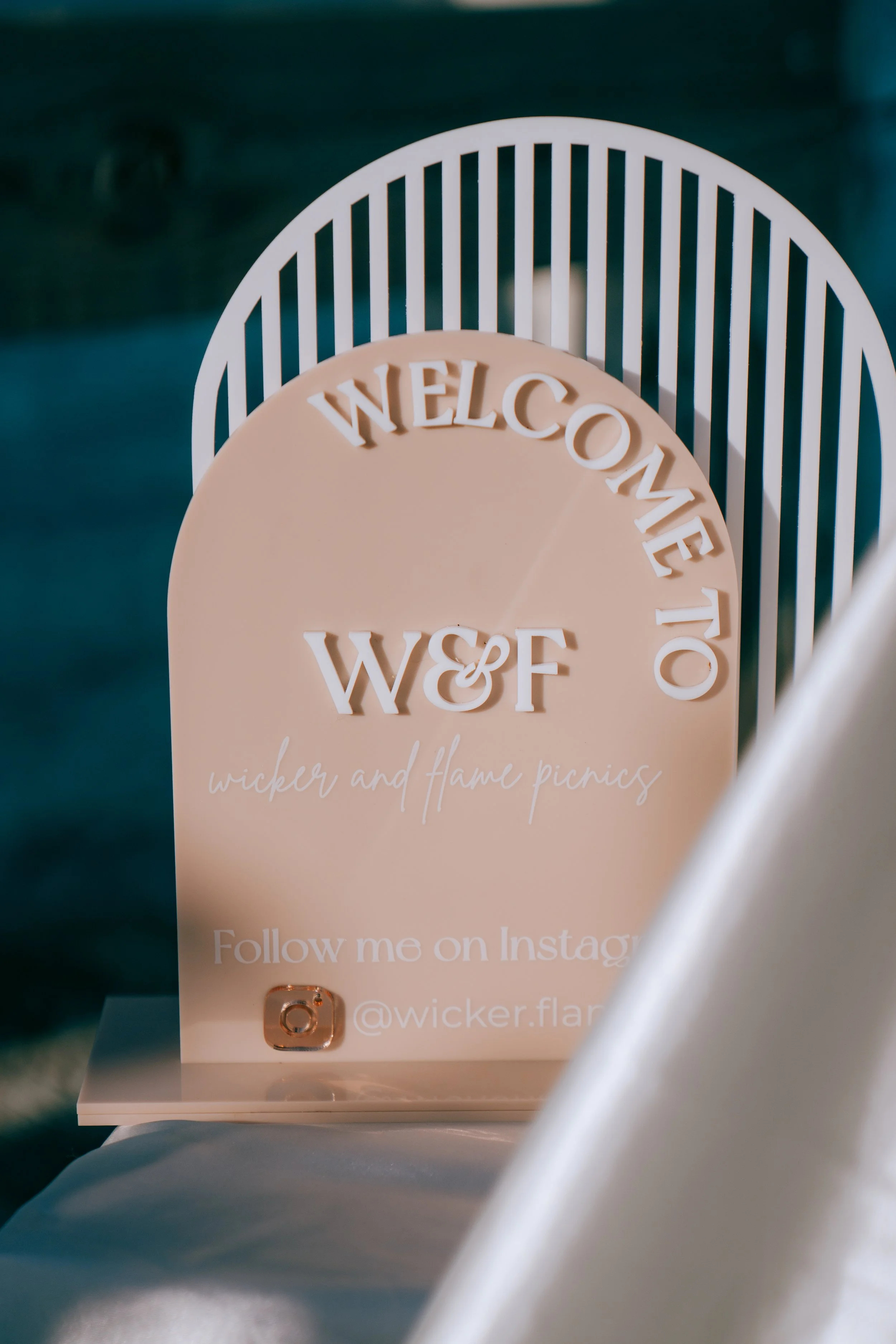 Luxury beach picnic setup with low tables, layered rugs, and coastal décor styling