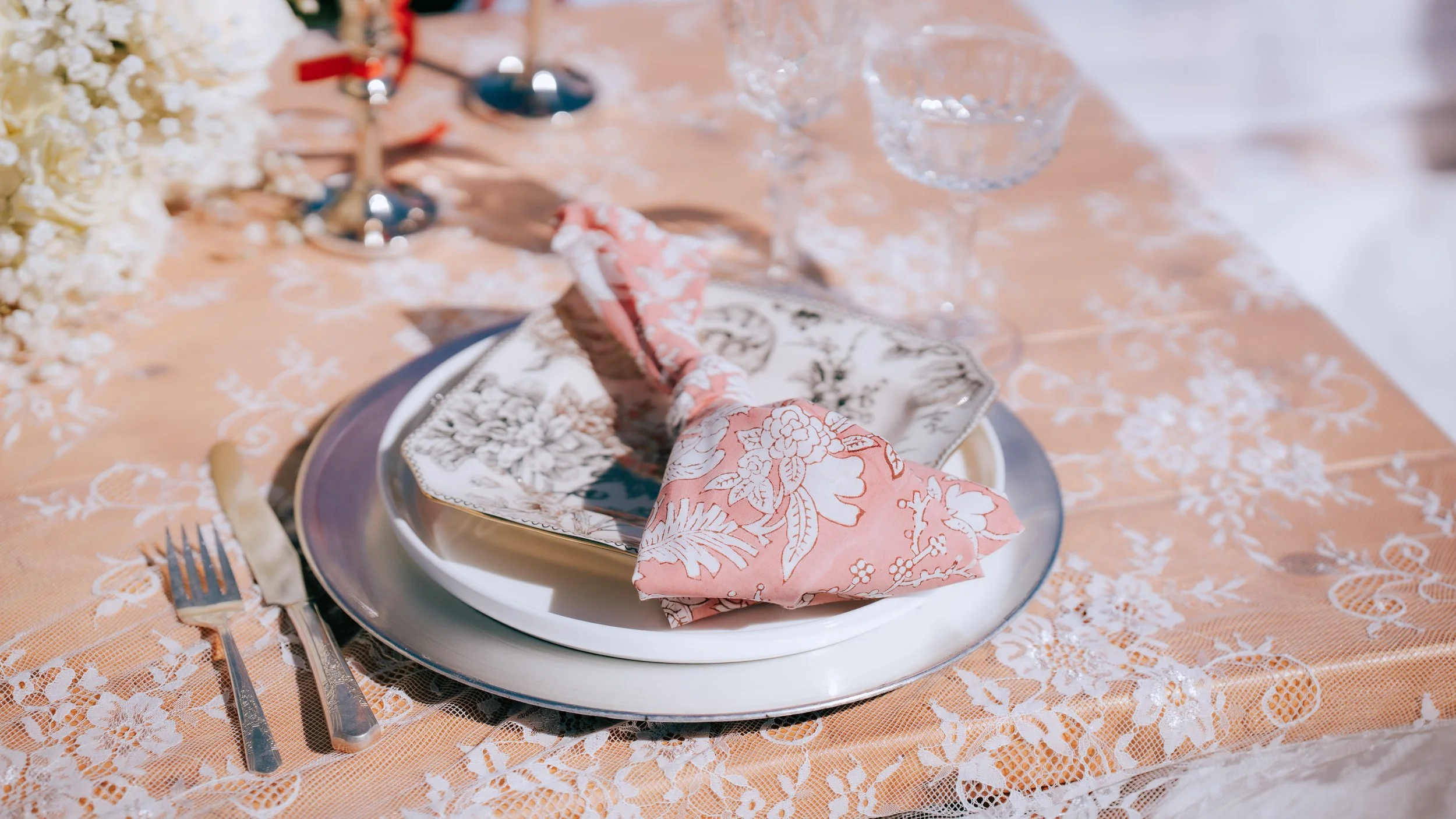 Romantic proposal picnic with champagne, florals, and ocean view backdrop