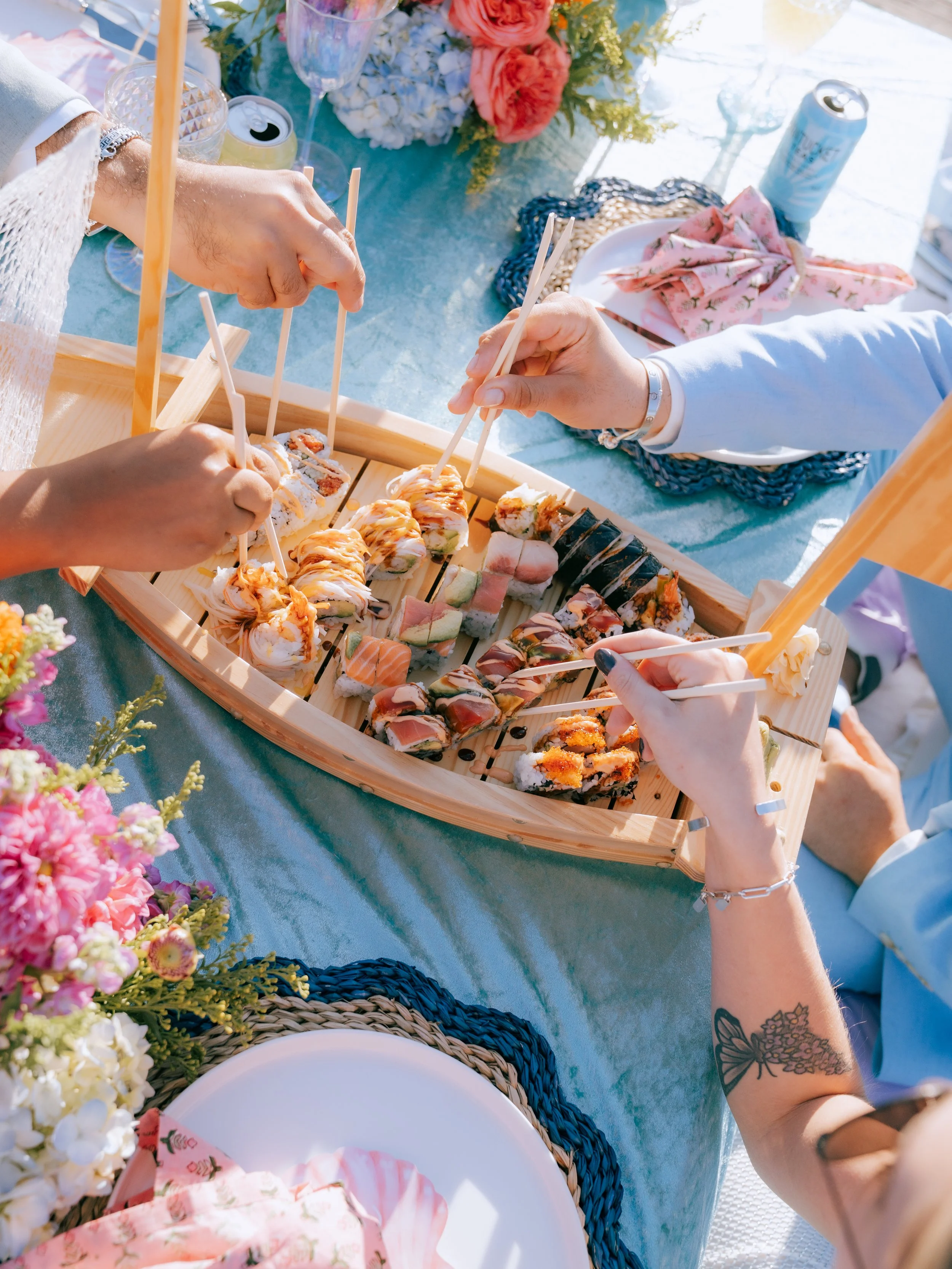 Luxury beach picnic setup with low tables, layered rugs, and coastal décor styling featuring Cisco Brewers