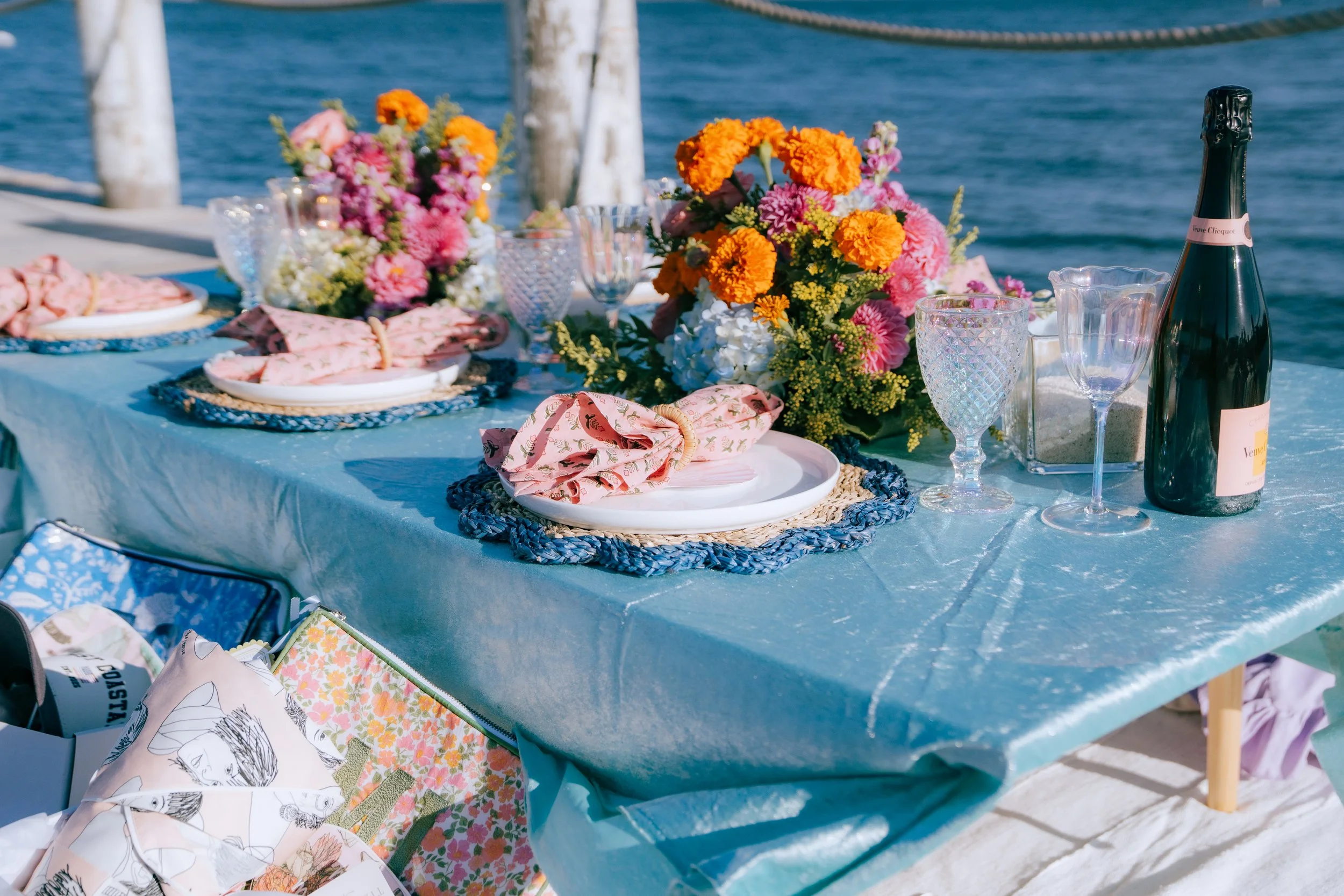 Luxury beach picnic setup with low tables, layered rugs, and coastal décor styling
