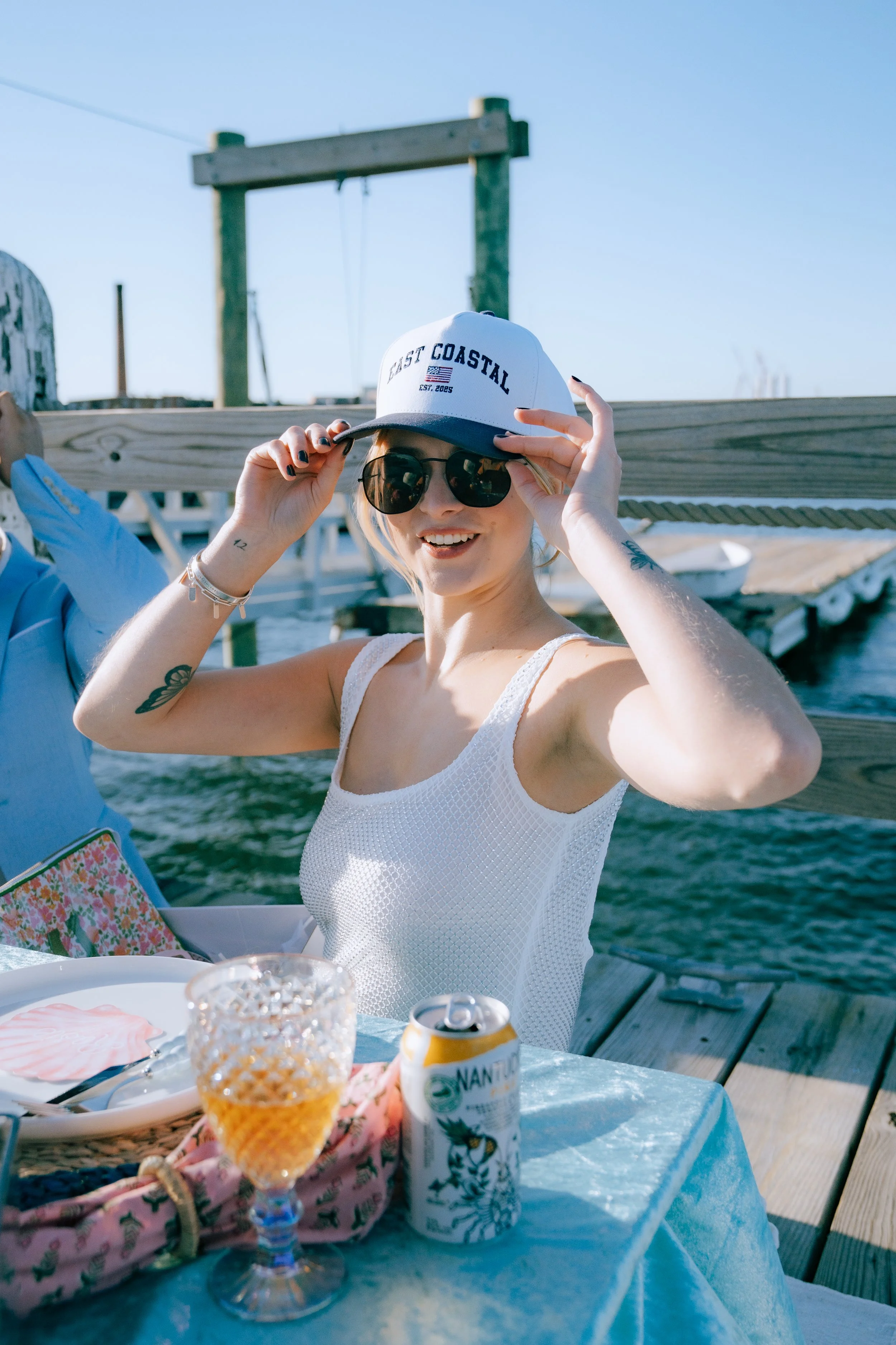 Luxury beach picnic setup with low tables, layered rugs, and coastal décor styling