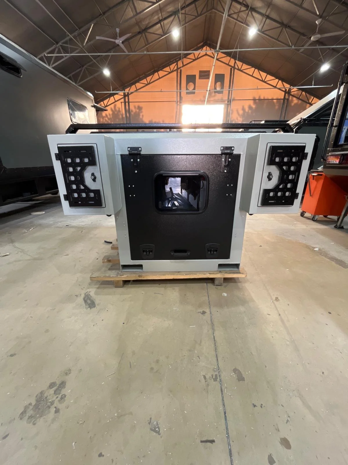 Demountable DEBOXS universal pickup storage system. Featuring integrated roof bars for roof cargo such as ladders, or rooftop tents, this rugged adventure and work canopy replacement offers a non-invasive mounting system that protects vehicle lease r