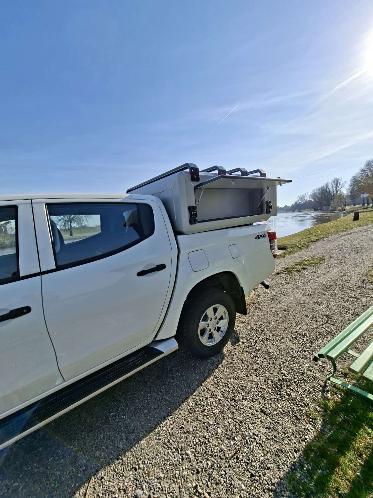 Demountable DEBOXS universal pickup storage system. Featuring integrated roof bars for roof cargo such as ladders, or rooftop tents, this rugged adventure and work canopy replacement offers a non-invasive mounting system that protects vehicle lease r