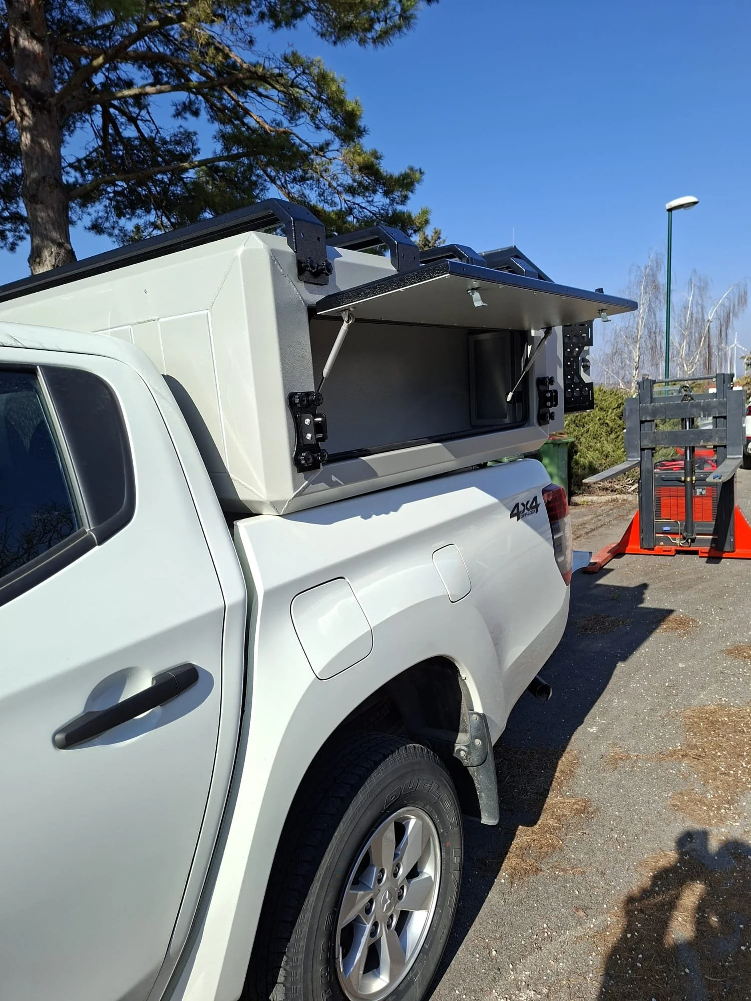 Demountable DEBOXS universal pickup storage system. Featuring integrated roof bars for roof cargo such as ladders, or rooftop tents, this rugged adventure and work canopy replacement offers a non-invasive mounting system that protects vehicle lease r