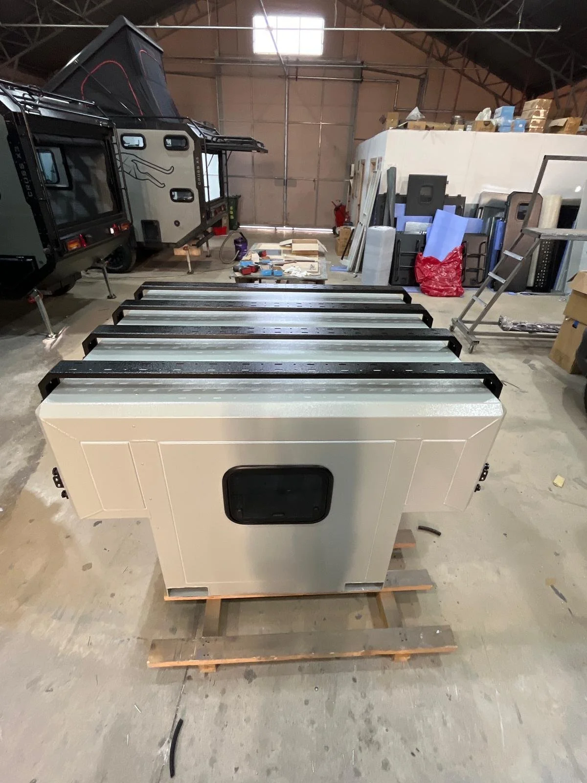 Demountable DEBOXS universal pickup storage system. Featuring integrated roof bars for roof cargo such as ladders, or rooftop tents, this rugged adventure and work canopy replacement offers a non-invasive mounting system that protects vehicle lease r