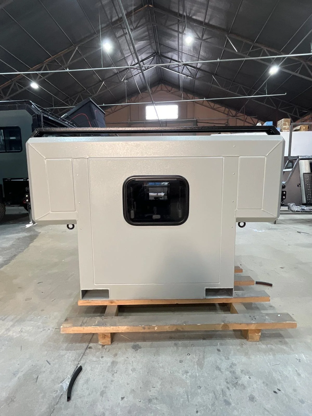 Demountable DEBOXS universal pickup storage system. Featuring integrated roof bars for roof cargo such as ladders, or rooftop tents, this rugged adventure and work canopy replacement offers a non-invasive mounting system that protects vehicle lease r