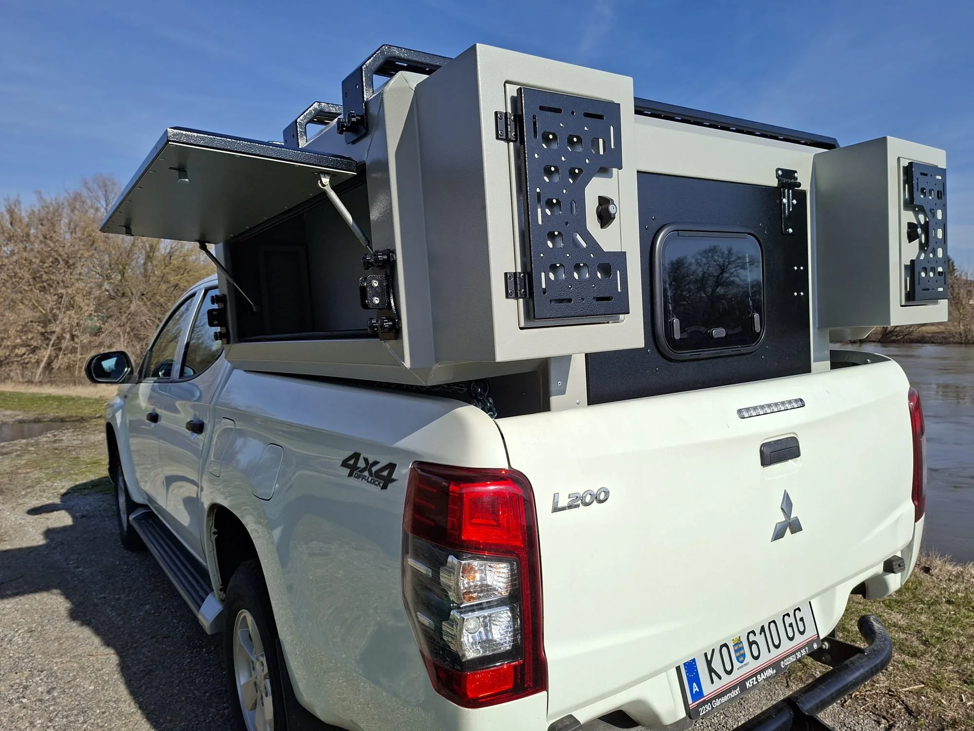 Demountable DEBOXS universal pickup storage system. Featuring integrated roof bars for roof cargo such as ladders, or rooftop tents, this rugged adventure and work canopy replacement offers a non-invasive mounting system that protects vehicle lease r