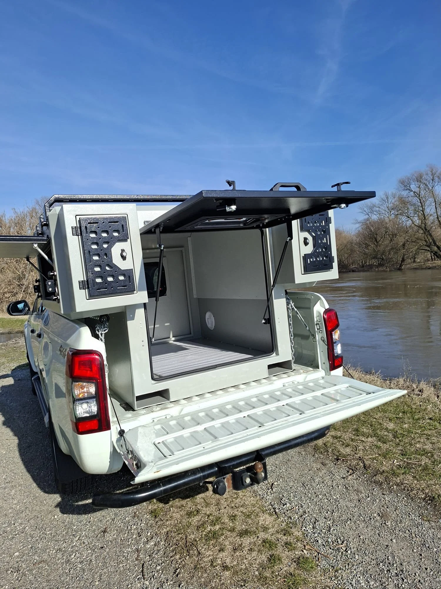 Demountable DEBOXS universal pickup storage system. Featuring integrated roof bars for roof cargo such as ladders, or rooftop tents, this rugged adventure and work canopy replacement offers a non-invasive mounting system that protects vehicle lease r