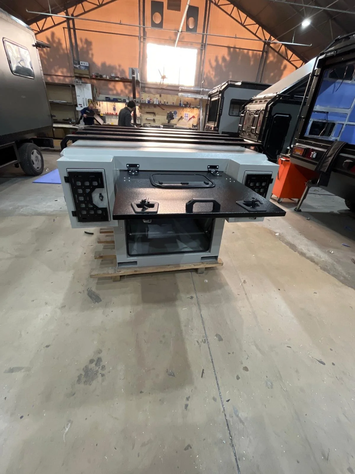 Demountable DEBOXS universal pickup storage system. Featuring integrated roof bars for roof cargo such as ladders, or rooftop tents, this rugged adventure and work canopy replacement offers a non-invasive mounting system that protects vehicle lease r