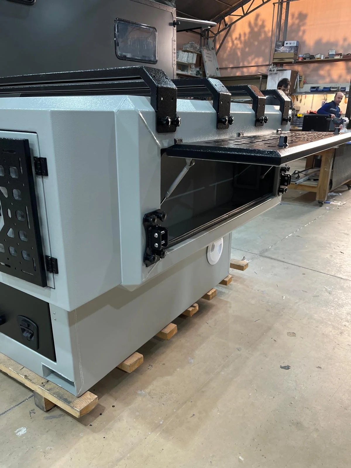 Demountable DEBOXS universal pickup storage system. Featuring integrated roof bars for roof cargo such as ladders, or rooftop tents, this rugged adventure and work canopy replacement offers a non-invasive mounting system that protects vehicle lease r