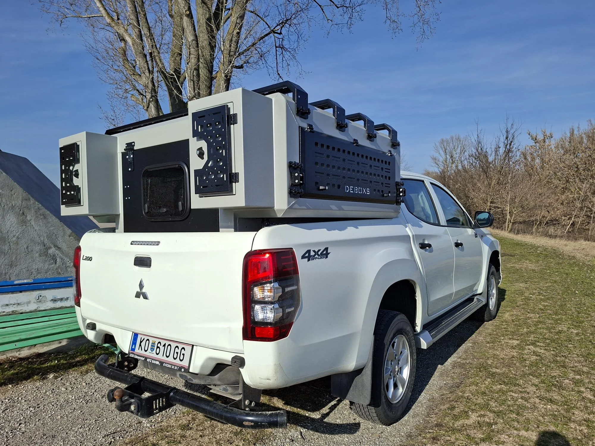 Demountable DEBOXS universal pickup storage system. Featuring integrated roof bars for roof cargo such as ladders, or rooftop tents, this rugged adventure and work canopy replacement offers a non-invasive mounting system that protects vehicle lease r