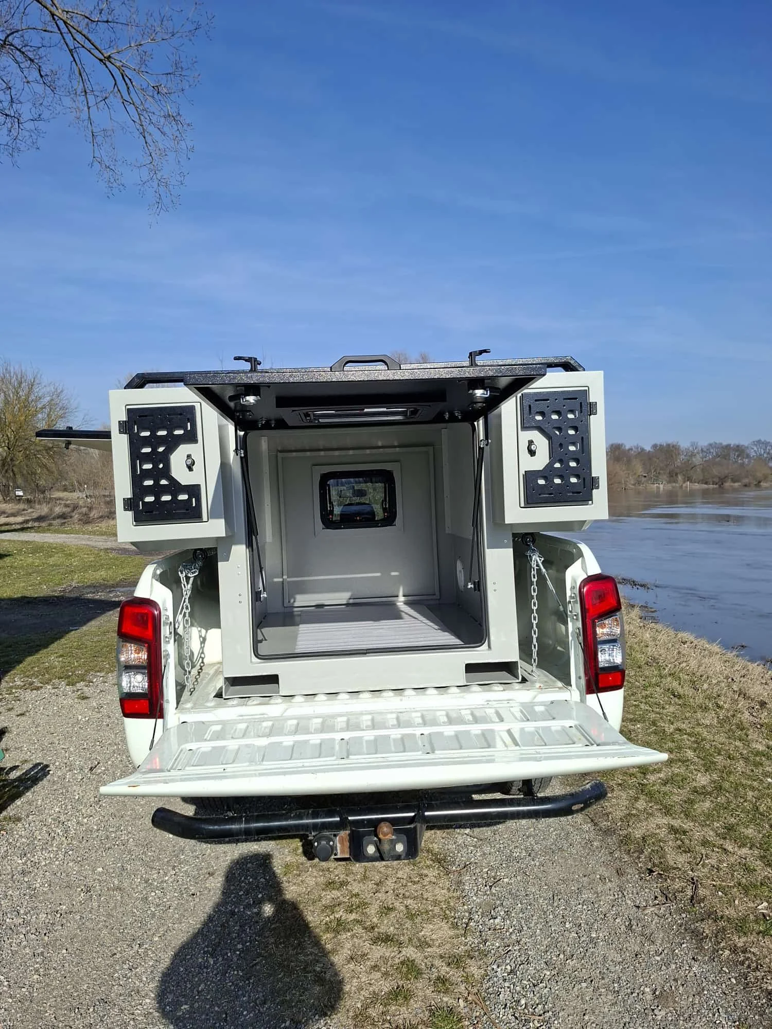 Demountable DEBOXS universal pickup storage system. Featuring integrated roof bars for roof cargo such as ladders, or rooftop tents, this rugged adventure and work canopy replacement offers a non-invasive mounting system that protects vehicle lease r