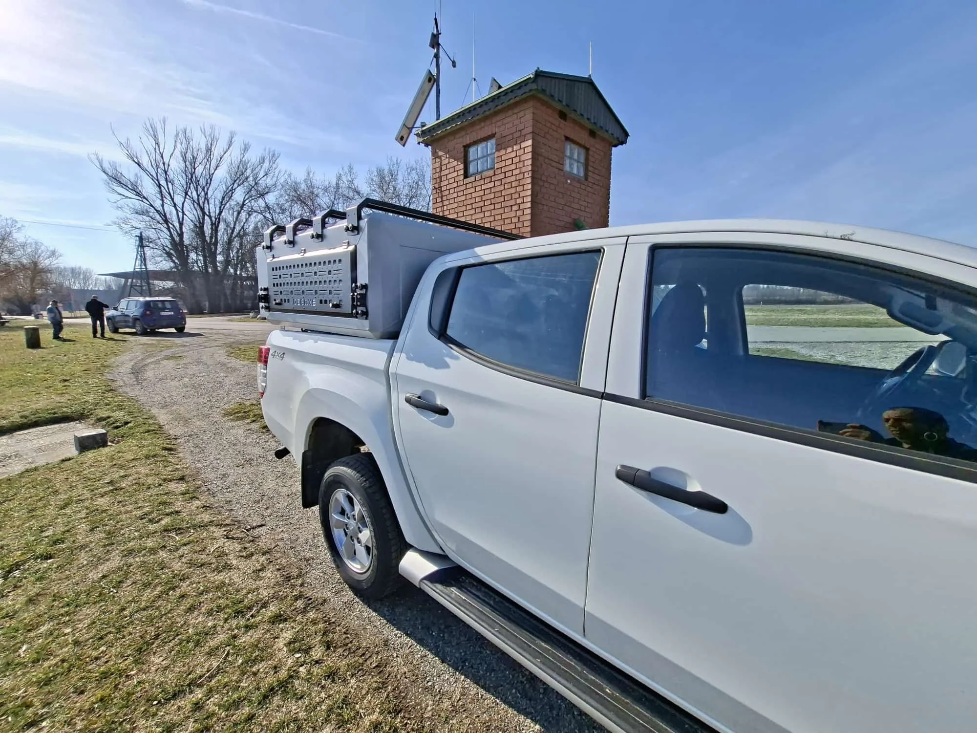 Demountable DEBOXS universal pickup storage system. Featuring integrated roof bars for roof cargo such as ladders, or rooftop tents, this rugged adventure and work canopy replacement offers a non-invasive mounting system that protects vehicle lease r