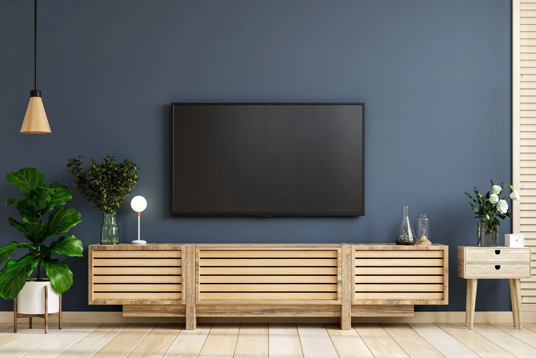 Modern living room with a dark wall, wooden sideboard with flat-screen TV on wall above.