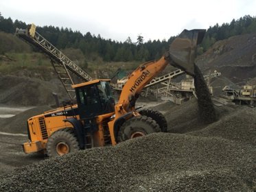gravel being moved by heavy machinery in the quarry