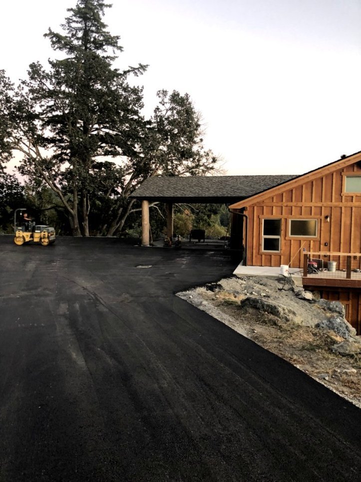a house with a fresh asphalt driveway