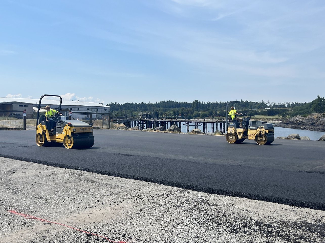 lawson workers rolling out asphalt on a road