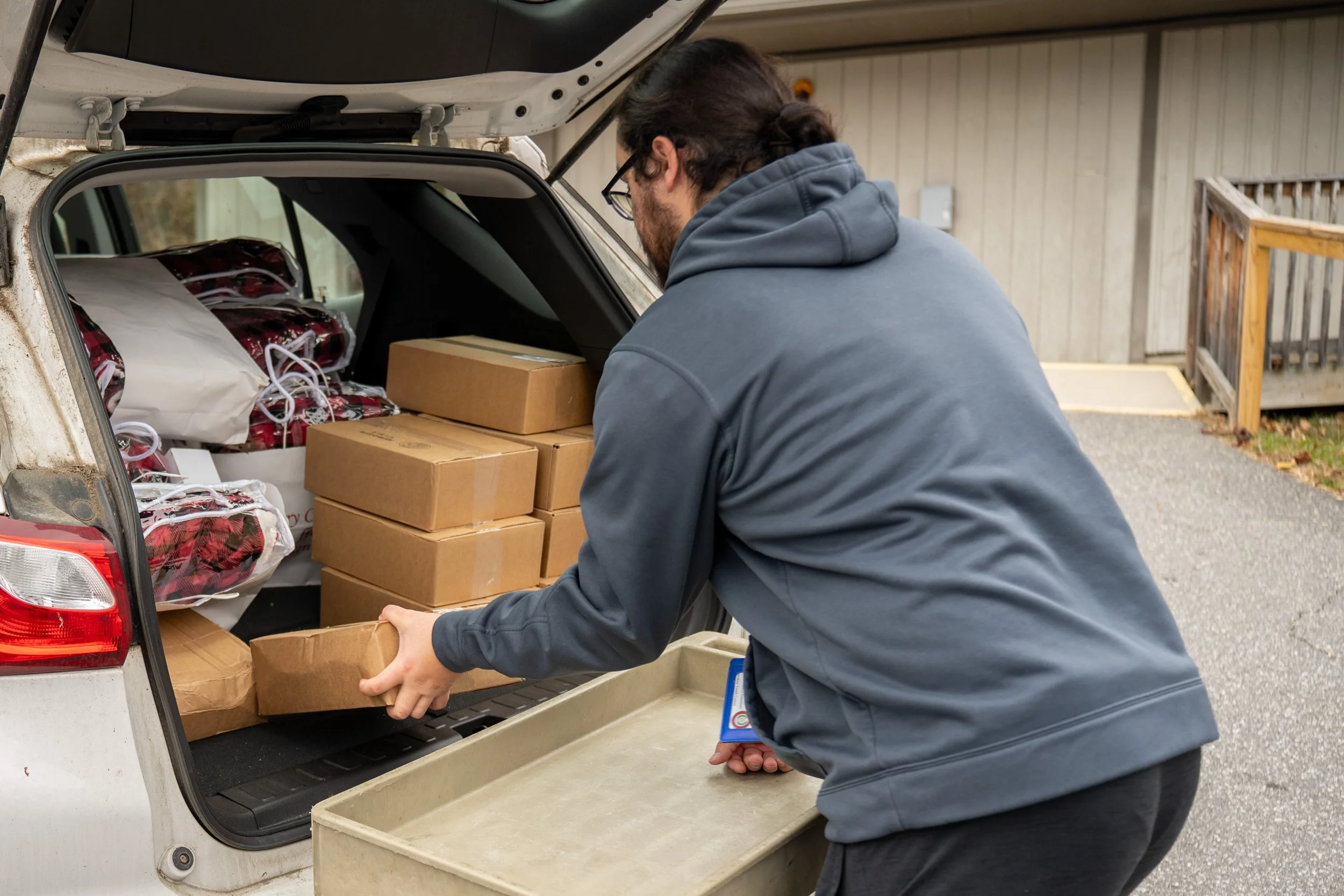someone loading food boxes into a car
