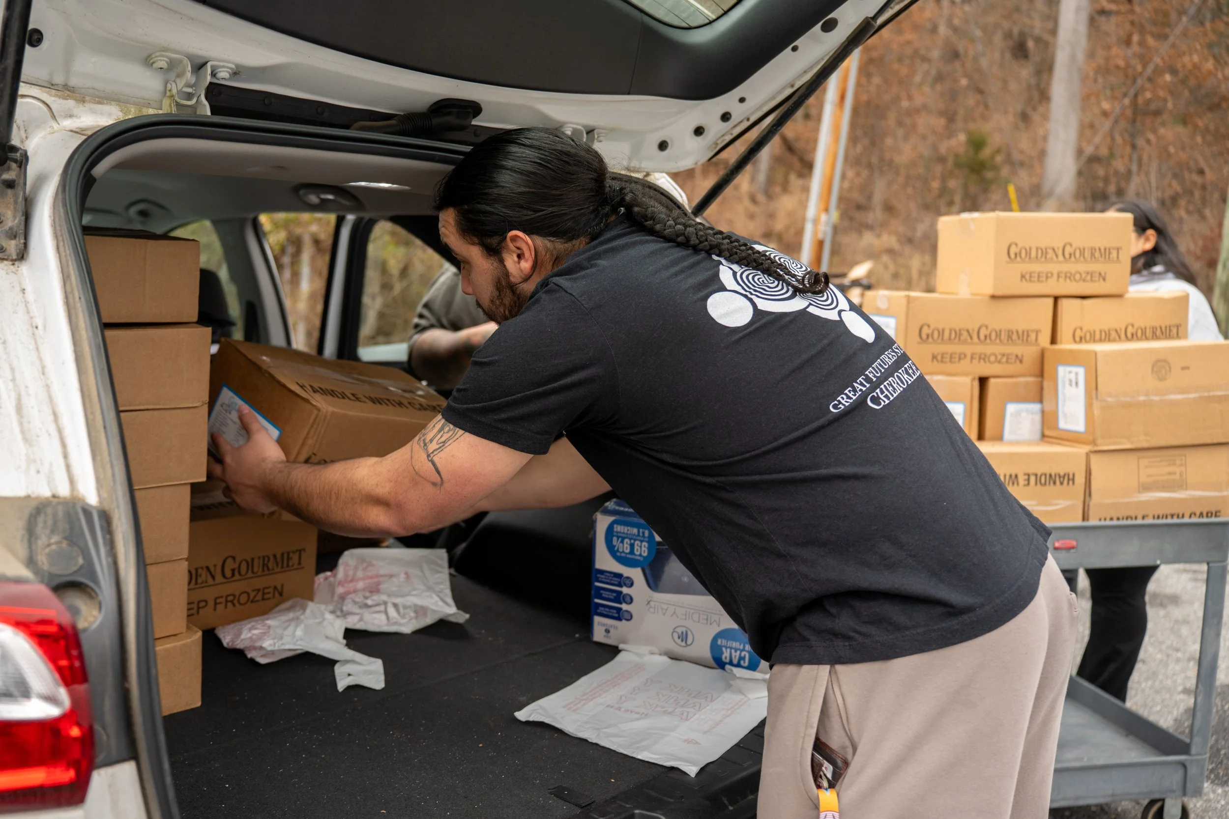 someone loading food boxes into a car