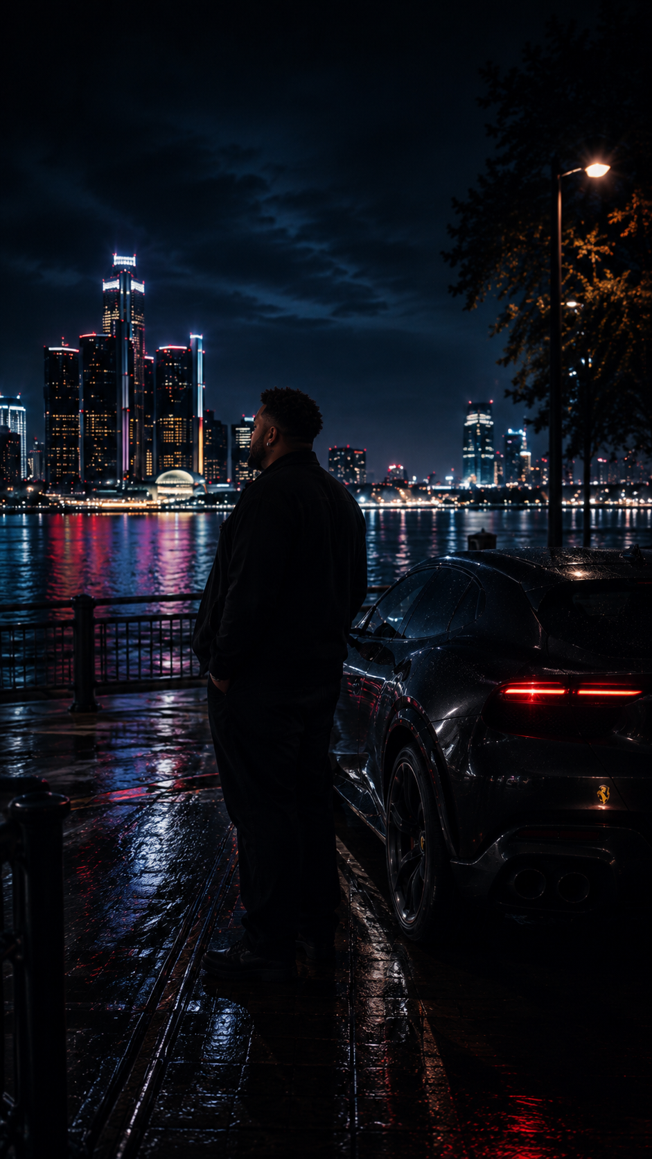 VYVYD standing by a vehicle on a rain-lit riverside overlooking the Detroit skyline at night.