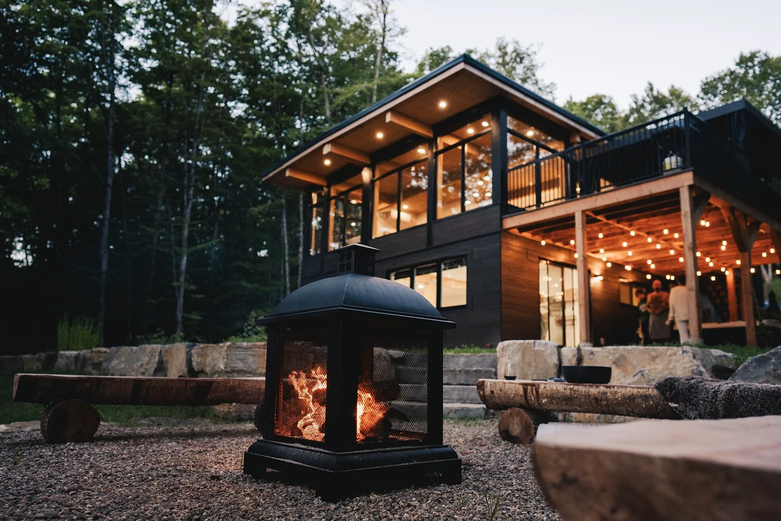 Ambiance chaleureuse autour du foyer extérieur, idéal pour des soirées conviviales sous les étoiles. Bois fourni et pare-étincelles sécuritaires.