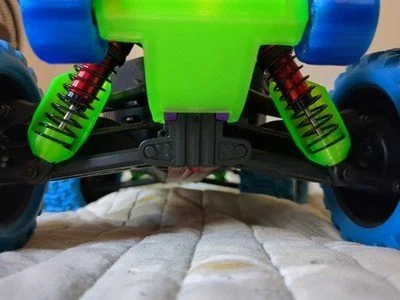 Close-up of the suspension and wheels of a remote-controlled off-road vehicle.