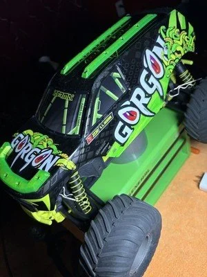 A remote-controlled car with black and neon green body, featuring the name 'Gorgon' on the side and a detailed dragon design on the top.
