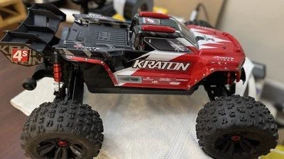 A red and black remote-controlled monster truck with large tires.