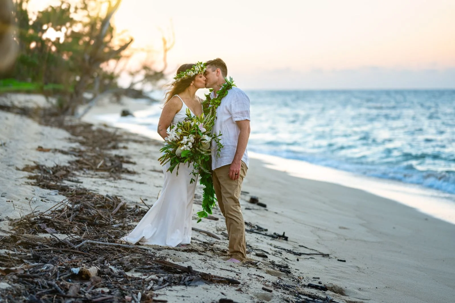 bride and groom kissing on beach in hawaii taken by aloha media