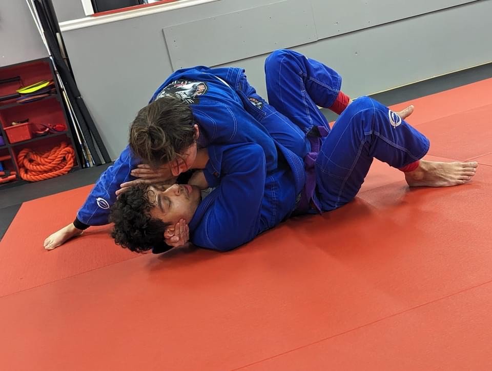 Adult students performing a Brazilian Jiu-Jitsu technique on the mat at Legacy Martial Arts Silver Spring MD