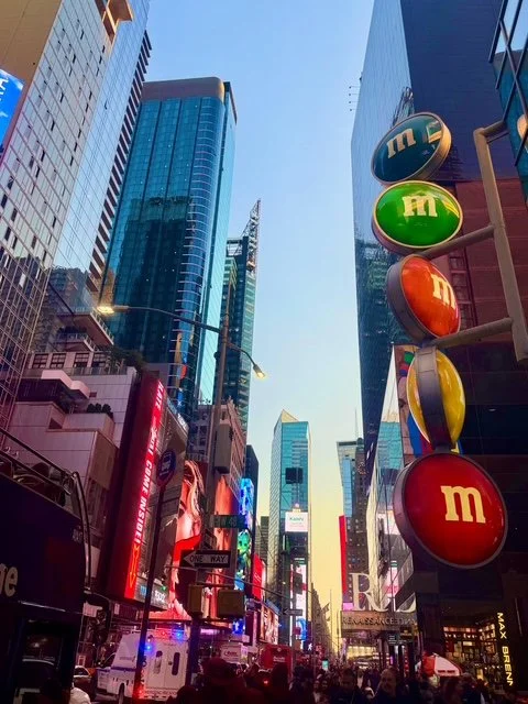 Times Square in New York met hoge gebouwen, felverlichte reclameborden en het bekende M&M’s Store bord. Populaire bezienswaardigheid tijdens een stedentrip New York.