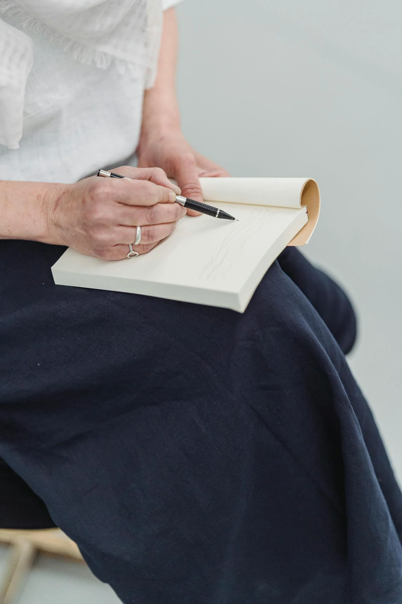individual and couples therapy. therapist in black skirt and white top writing in journal