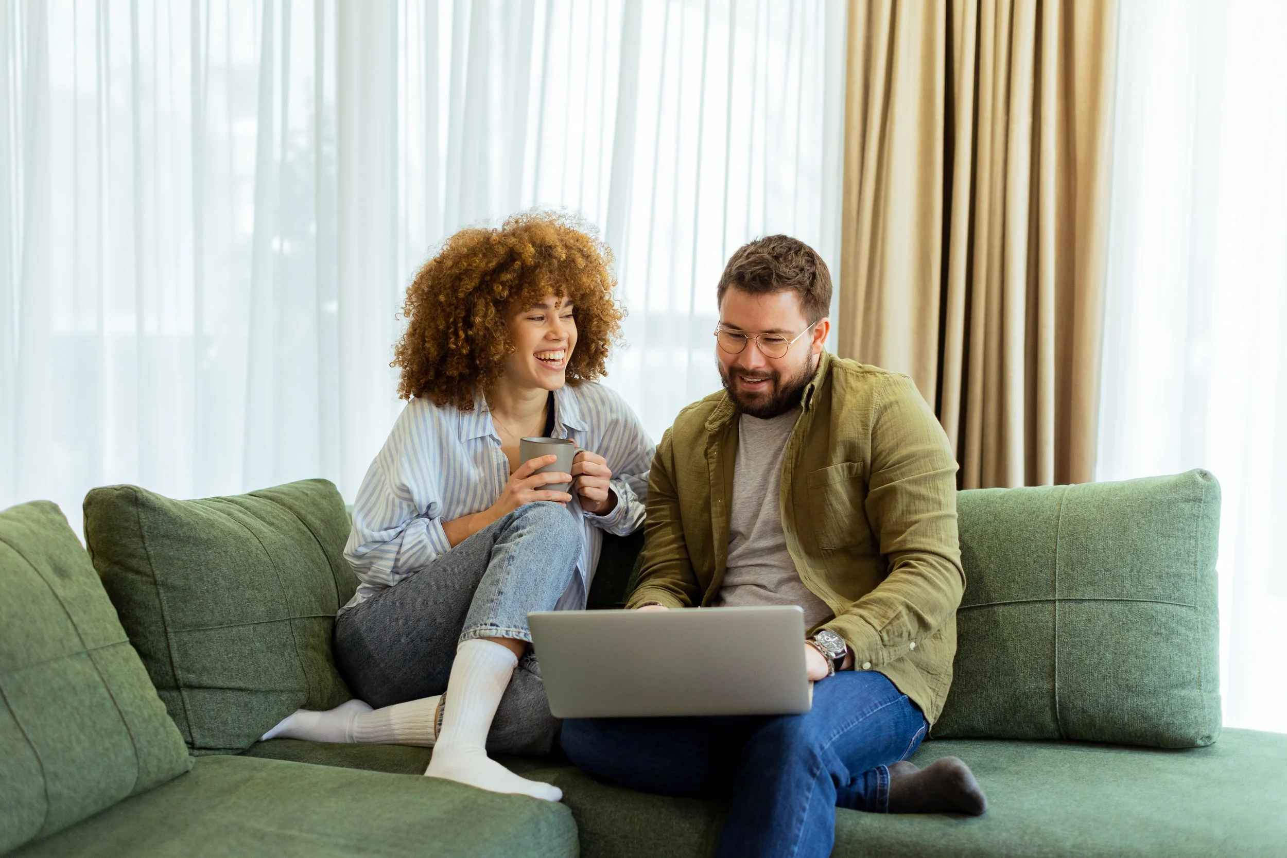 Couple on a couch researching a couples therapist Houston online, exploring support with a relationship therapist Heights provider.