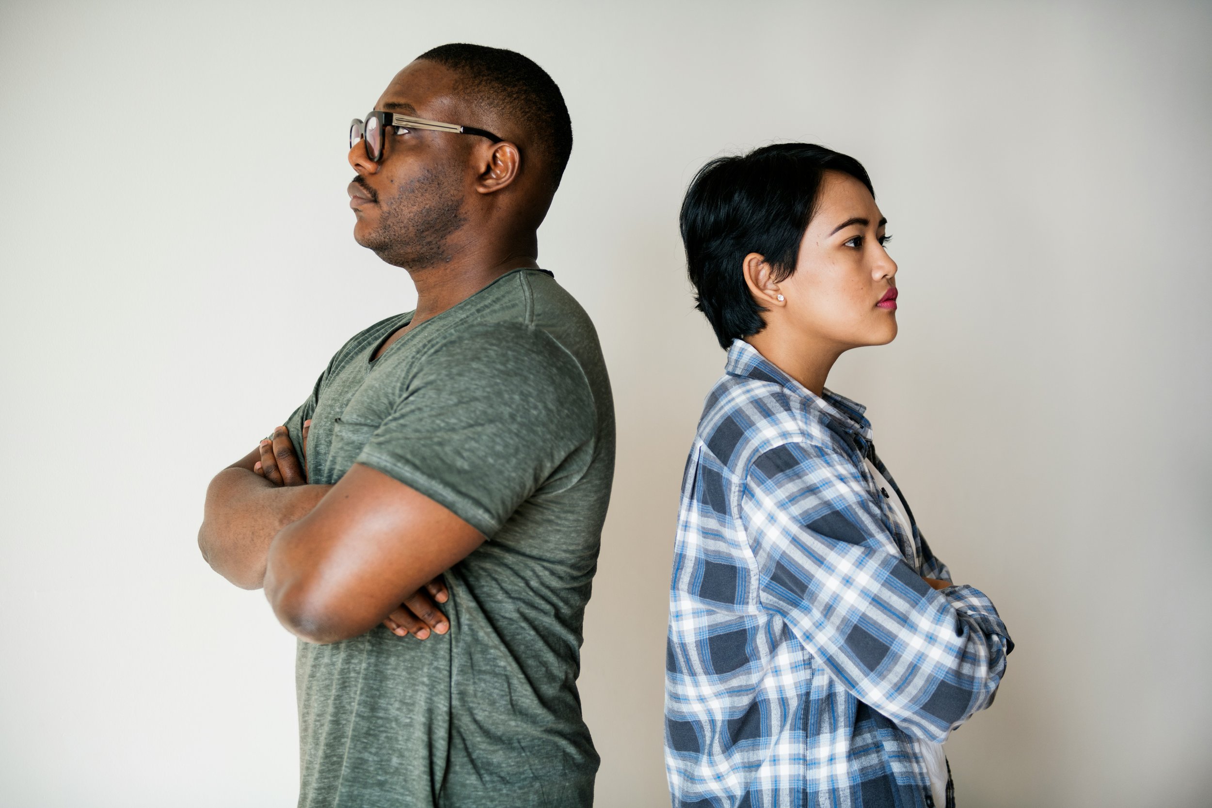 A couple stands back to back not speaking because they're stuck in the same conflict cycle they've gone over many times before. They know it's time to reach out to Heights Couples Therapy in Houston to help them stop the cycle.