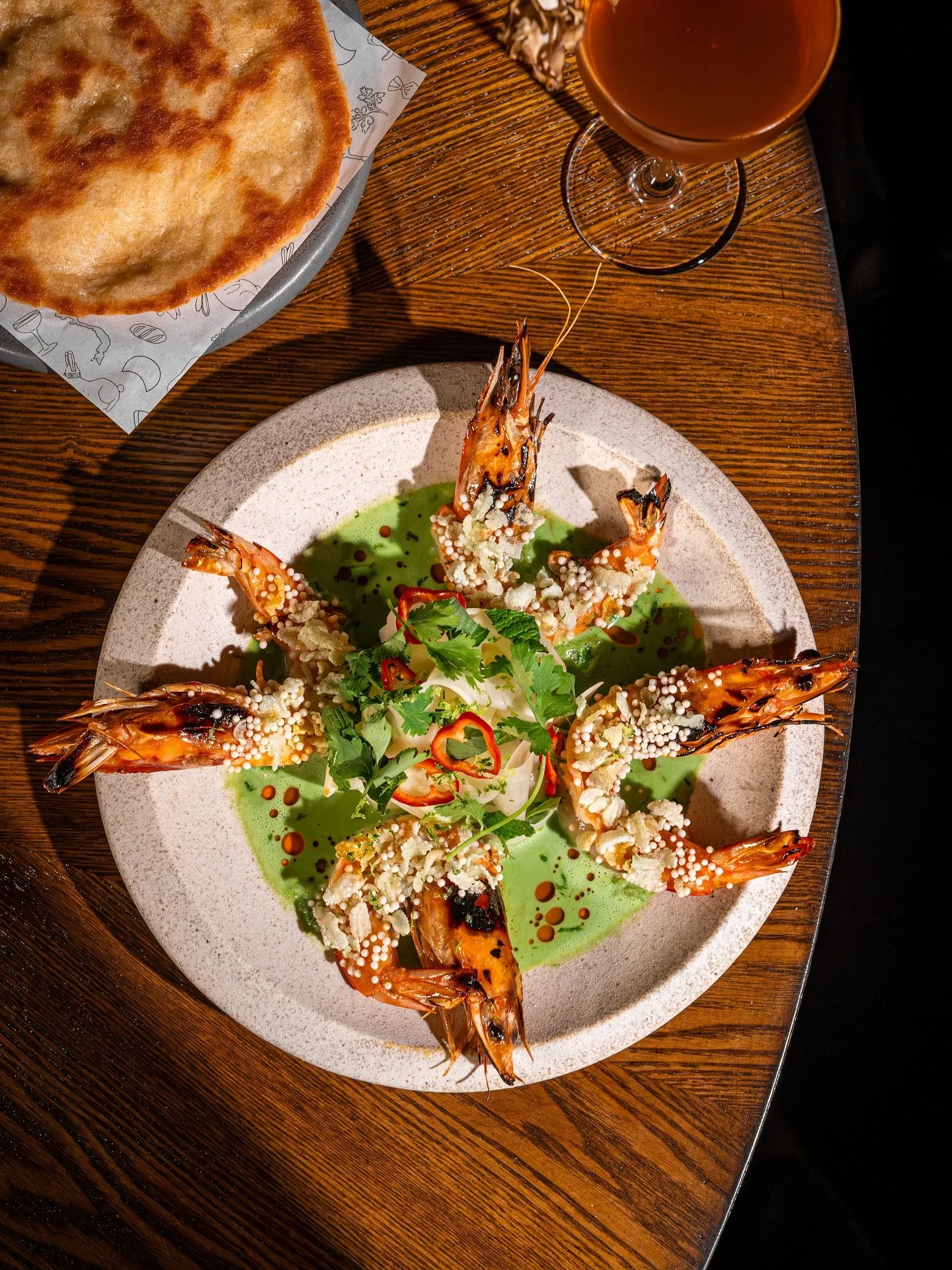 𝐂𝐮𝐫𝐫𝐲 𝐏𝐫𝐚𝐰𝐧𝐬 | 𝐓&ocirc;𝐦 𝐂𝐡𝐢&ecirc;𝐧 𝐂ố𝐦
green curry, papaya salad, tamarind glaze, aji dulce, puffed rice, fry bread

This dish begins with a memory of t&ocirc;m chi&ecirc;n cốm&mdash;a Vietnamese street food made with shrimp coat