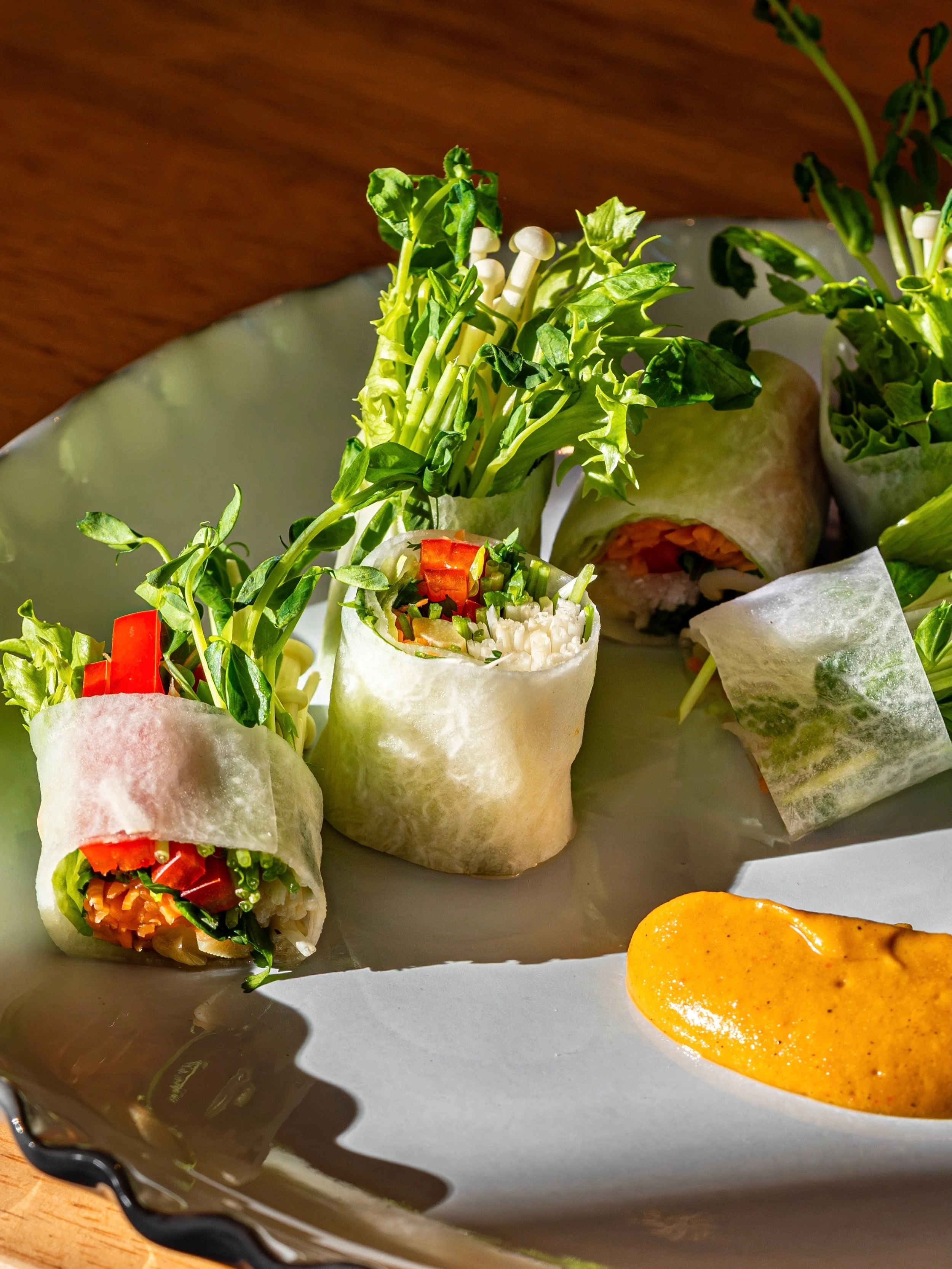 With our Summer Roll | Gỏi Cuốn, we wanted to explore what a familiar Vietnamese dish could become with a different wrapper. Thin sheets of daikon replace the traditional rice paper, bringing a crisp bite to the hearts of palm and seasonal vegetables