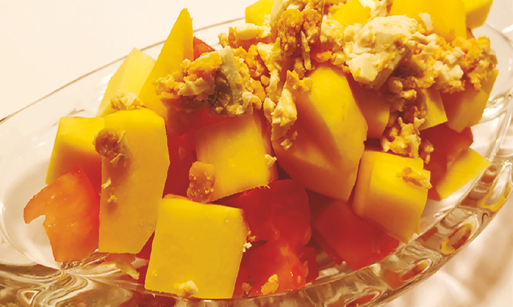 Diced mango and tomato salad topped with salted egg pieces