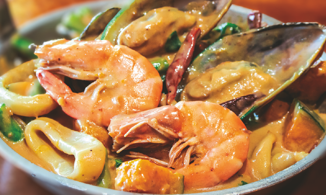 Prawns, squid, and mussels in spicy coconut sauce with squash and green beans.