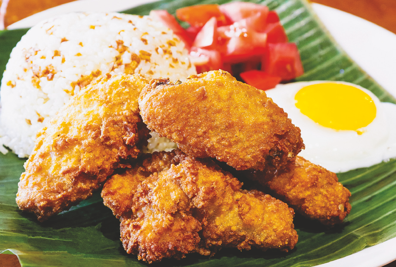 Deep fried chicken wings with flavorful breading served with rice, fried egg, and tomato