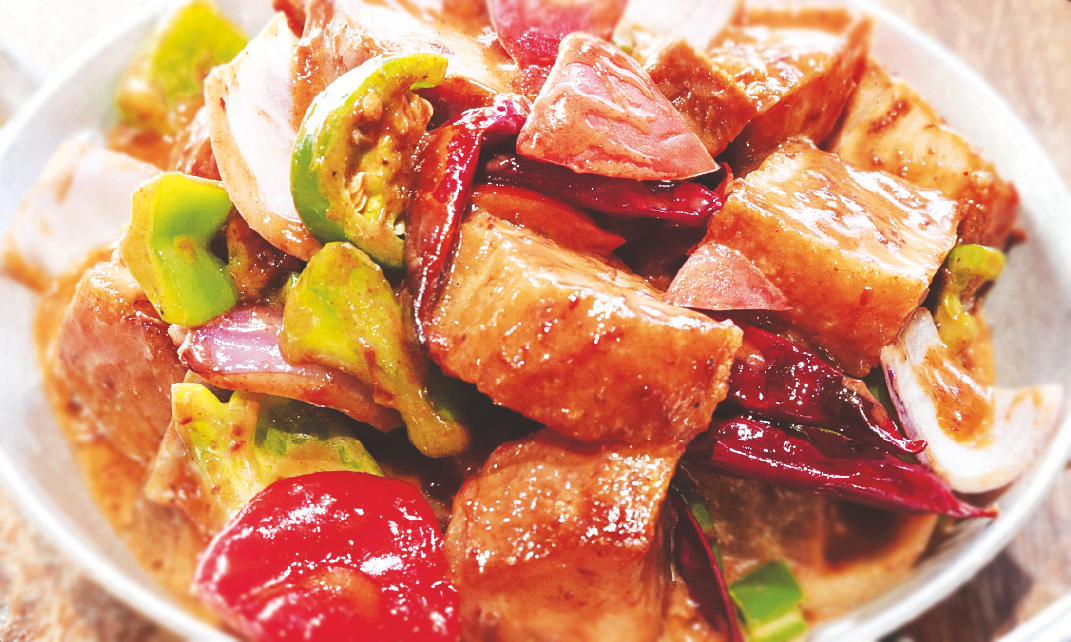 Crispy diced pork belly in spicy coconut sauce with shrimp paste, onions, bell peppers, and tomatoes