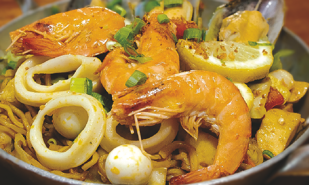 Egg noodles cooked with mussels, calamari, shrimp, squid balls, quail eggs, and vegetables.
